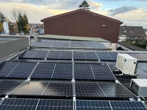 Photovoltaikanlage auf dem Flachdach eines Industriegebäudes, bestehend aus mehreren Solarmodulen.